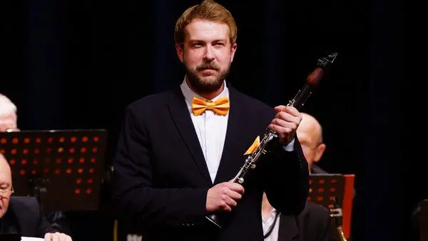 Высокий блондин с кларнетом и оркестром